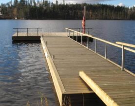 Holzponton mit Betonschwimmer, Stegbrücke und Geländer auf dem Wasser