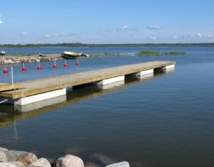 Holzponton mit Betonschwimmer und Ankerbojen im Hafen Kungla