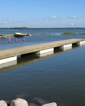 Holzponton mit Betonschwimmer und Ankerbojen im Hafen Kungla